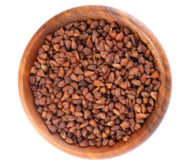 Buckwheat tea in wooden bowl, isolated on white background. Whole roasted buckwheat grains. Fagopyrum tataricum. Top view.