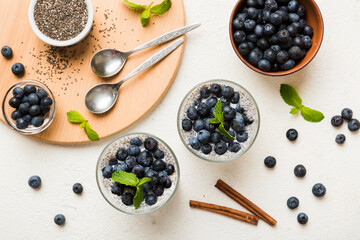 Healthy breakfast or morning with chia seeds vanilla pudding and blueberry berries on table background, vegetarian food, diet and health concept. Chia pudding with coconut milk and blueberry