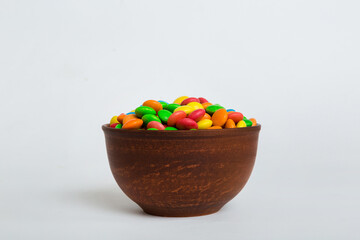 Multicolored candies in a bowl on a colored background. birthday and holiday concept. Top view with copy space
