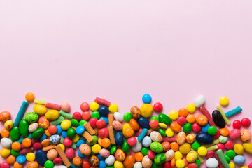 Mixed collection of colorful candy, on colored background. Flat lay, top view. frame of colorful chocolate coated candy