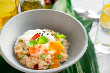 Risotto with shrimp and vegetables served in a bowl, close up