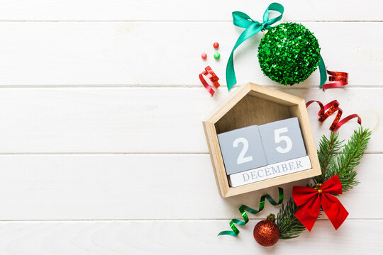 Christmas calendar 25 december. Christmas gift, fir branches, pine cones. Flat lay, top view. New Year decorations on a colored background