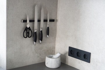 Set of knives on magnetic holder. Knife set placed in a magnetic restraint. Home knives magnetic bar.