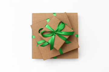 Top view of craft present boxes with green ribbons on the white background