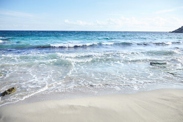 Fototapeta na wymiar Sand beach, summer sea with blue sky. Sea water with white wave. Cala azzurra beach, Favignana island, Trapani, Sicily, Italy. A beautiful seascape