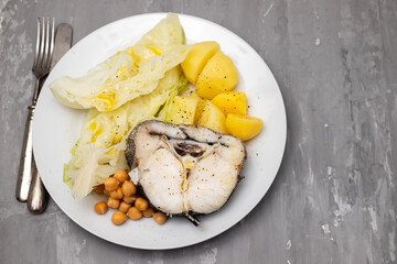 boiled vegetables with boiled fish on white plate