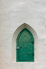 Fototapeta na wymiar old vintage green door in a white house