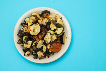 Mixed baked vegetables on light brown dish