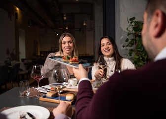 Group of Happy friends having lunch in the restaurant. Sharing food