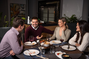 Happy business colleagues talking while eating lunch in a restaurant