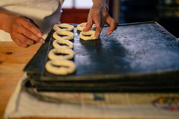 Manos de un hombre trabajando con masa y harina de trigo en una panaderia. Manos de repostero haciendo galletas.  - obrazy, fototapety, plakaty
