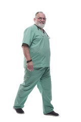 Fototapeta premium in full growth. Mature doctor with a stethoscope confidently stepping forward