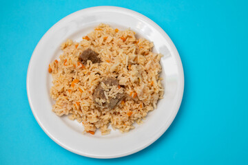 Rice with vegetables and meat on white plate
