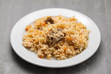 Rice with vegetables and meat on white plate