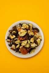 Mixed baked vegetables on light brown dish