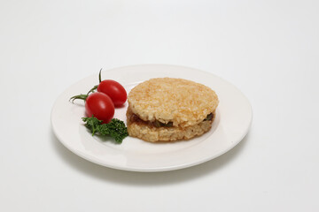 白背景の白い皿にのせたライスバーガー