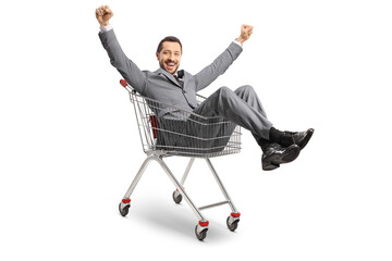 Businessman sitting inside a shopping cart and gesturing happiness © Ljupco Smokovski