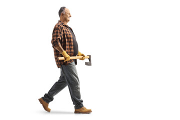 Full length profile shot of a mature man walking and holding an axe