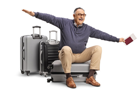 Mature man sitting on a suitcase and gesturing flying