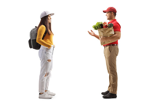 Full Length Profile Shot Of A Female Student Talking To A Delivery Man With A Grocery Bag