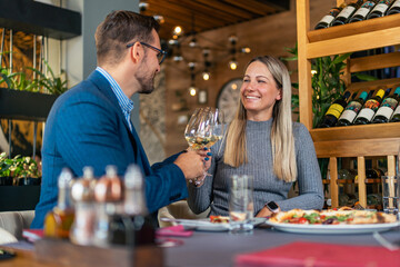 young, lovely couple making a toast for many more beautiful moments, with quality and rich white wine in the restaurant