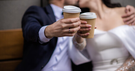 hands of bride and groom with rings. bride and groom in a cafe. wedding bouquet table. bride and groom hold each other's hands. Wedding rings. Loving couple in a cafe. hot tea for lovers