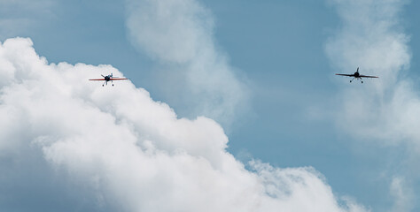 two planes flying head-on over a sky blue sky with white clouds. concept company and care.