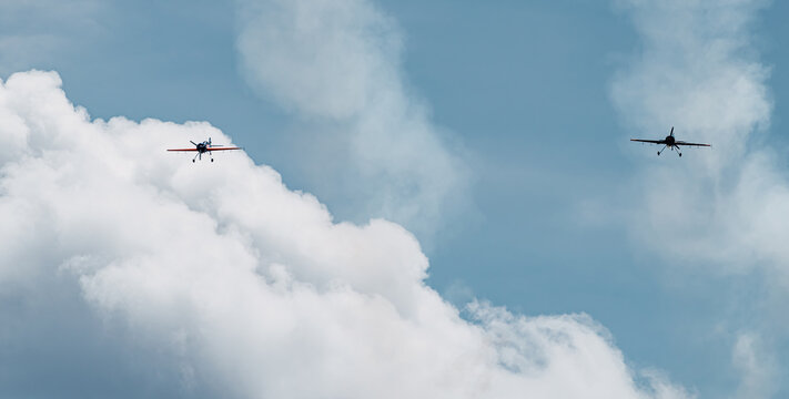 Two Planes Flying Head-on Over A Sky Blue Sky With White Clouds. Concept Company And Care.