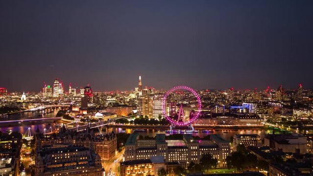 Aerial Panoramic Helicopter View Of  City of London Skyline Palace of Westminster Big Ben The London Eye Wheel And Thames River Purple Illuminated Hyper-lapse Time Lapse Central London View