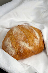 Homemade bread wrapped in white tablecloth