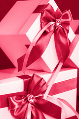The gift box is white with a beautiful gray bow. Gift on a dark background. Holidays and surprises. Satin bows with rhinestones...Viva Magenta Background color