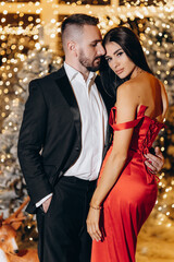 Sexy elegant couple. New Year Tree.