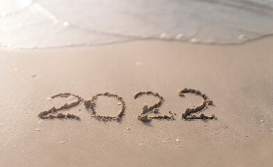 The numbers 2022 are washed away by the sea waves of the Persian Gulf. The concept of a change of years