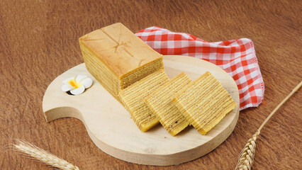 Spekkoek (kue lapis legit or spekuk in Indonesian) is a type of Indonesian layer cake. selective focus. it served on wooden plate