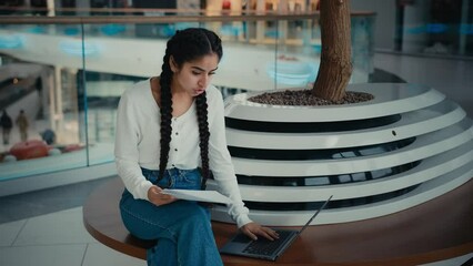 Female young student tutor business woman sit at shopping center use video call application on laptop chatting online reporting to client financial result reading documents conduct educational webinar - Powered by Adobe