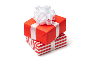 Close up shot of pile of two gift boxes wrapped in red and striped paper isolated and decorated with satin ribbon bows, isolated over white background