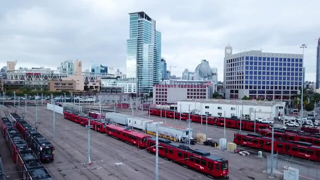 Upward Slow Panning Drone Clip of the San Diego MTS Trolley Railyard, Petco Park, and Downtown With 2 Birds Flying Through The Shot