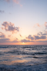 Dusk sunset on a dramatic cloudy sky over the Mediterranean sea. Sea with waves