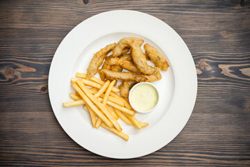 menu with fried shrimp and french fries with sauce on a plate.
