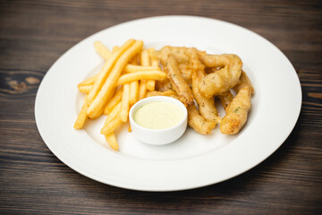 menu with fried shrimp and french fries with sauce on a plate.