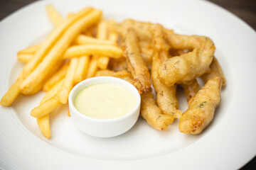 menu with fried shrimp and french fries with sauce on a plate.