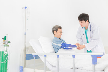 Fototapeta premium asian patient talk with doctor in hospital, doctor assessment and explaining about treatment information, patient wear arm splint, elderly healthcare treatment