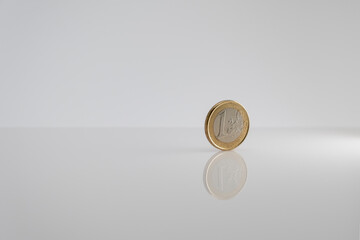 One euro coin isolated on light gray background with reflection. Copy space.