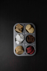 assorted sugar cookies in a cupcake tin