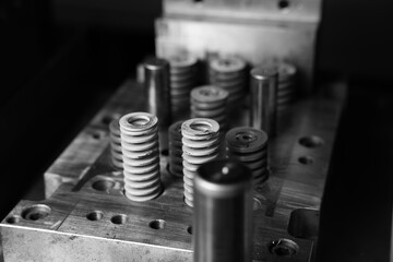 Naklejka premium Sheet Metal Stamping Tool Die for Automotive Precision Parts on The Numerical Control Milling Machine Table. Tandem Stamping System. At a High Quality Technology Factory. Black and White Photography.