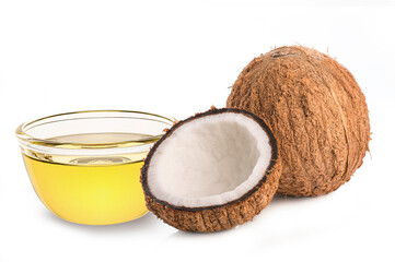 coconut oil in glass bowl with coconut and half on white background.