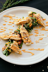 Black bottom dish, chicken with salad and dressing. Lunch.