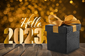 Hello 2023. Beautiful gift box on wooden table against blurred festive lights, bokeh effect
