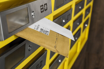 Metal mailboxes with keyholes, numbers and correspondence in post office, closeup