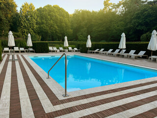 Outdoor swimming pool in luxury hotel on sunny summer day. Time for relax